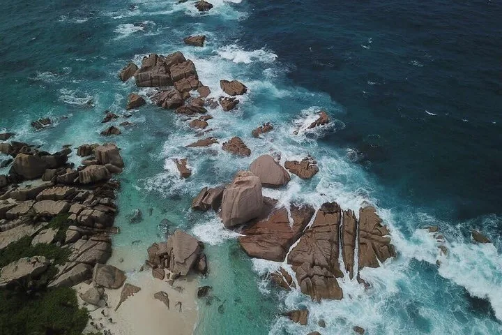 Drone shot of ocean waves and large granite rock formations
